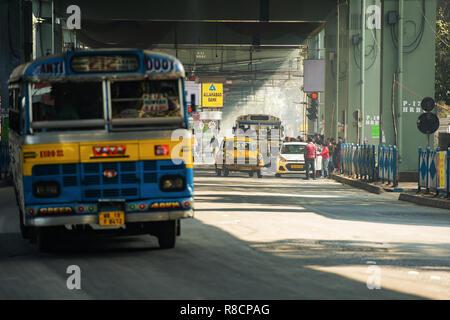 Alcuni Ambasciatore cabina taxi, gli autobus e le persone attraverso le strade di Calcutta. Foto Stock