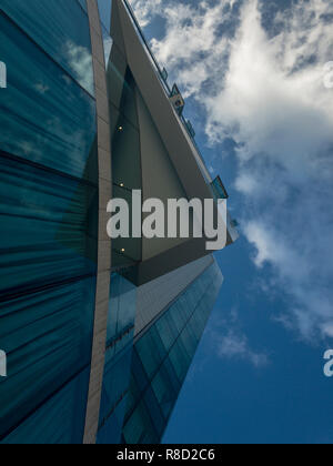 Palazzo moderno di architettura, vetri riflettenti, palazzo di vetro. Il cielo si specchia nelle finestre di un edificio. Nuvole nel cielo, gli angoli e spigoli di un cielo Foto Stock