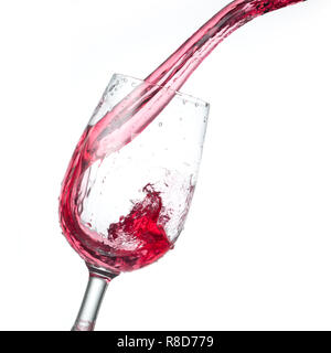 Vino rosso versando in vetro isolato su sfondo bianco, studio foto Foto Stock