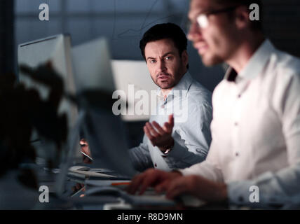 Close up.due colleghi un lavoro notturno in ufficio. Foto Stock