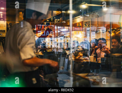 La riflessione di una strada trafficata nel centro cittadino di Sapporo da un ristorante la finestra. Chuo Ward, Sapporo, Hokkaido, Giappone. Foto Stock