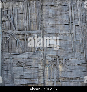 La trama di grigio rotto alterò la parete in legno. Età compresa tra asse di legno recinzione di incrinato i fogli di legno. Foto Stock