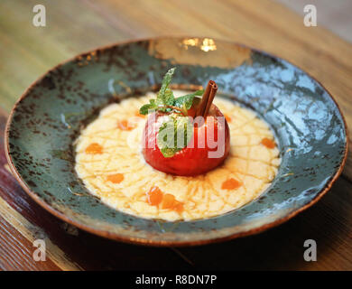 Luminoso dello sfondo della foto macro di miglio di deliziosa crema di farina e di latte con cannella e Apple in una piastra di colore blu Foto Stock