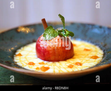 Luminoso dello sfondo della foto macro di miglio di deliziosa crema di farina e di latte con cannella e Apple in una piastra di colore blu Foto Stock