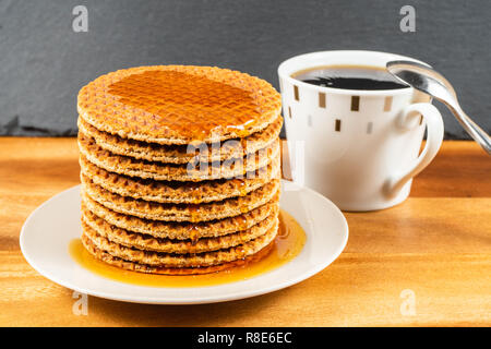 Cialde a caldo con sciroppo d'acero.Miele versando su un waffles freschi. Foto Stock