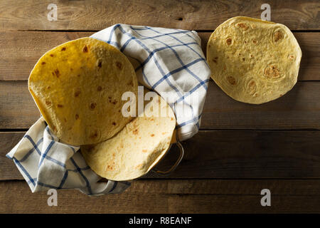 Fresche, svuotare il frumento tortilla flat top laici vista su uno strofinaccio sulla tavola in legno rustico sfondo Foto Stock