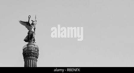 La statua dorata di Victoria sulla parte superiore della colonna della vittoria di Berlino in Germania contro un cielo blu con copia spazio, in bianco e nero Foto Stock