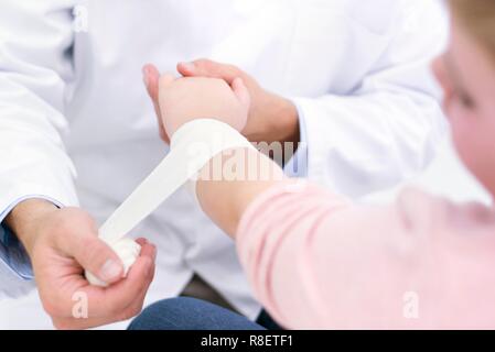 Medico del bendaggio ragazza polso. Foto Stock