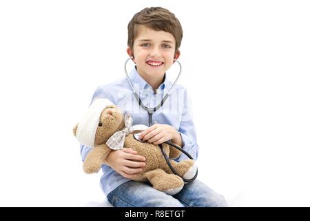 Ragazzo giocando con Teddy bear e stetoscopio. Foto Stock