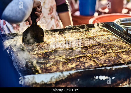 La cottura di Murtabak - tradizionali asiatici torte con riempimento interno. Classica asiatica cucina di strada da l'isola di Langkawi in Malaysia. Close up. Foto Stock