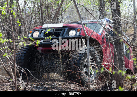 Suzuki Jimny è acqua di attraversamento di ostacolo nella foresta di primavera Foto Stock