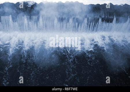 Diga per regolare il livello di acqua nel fiume. Caduta di acqua monocromatico con forti raffiche Foto Stock