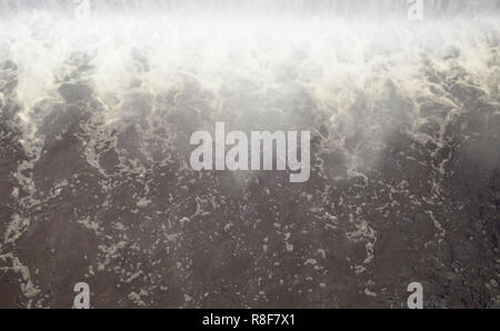 Diga per regolare il livello di acqua nel fiume. Caduta di acqua monocromatico con forti raffiche Foto Stock