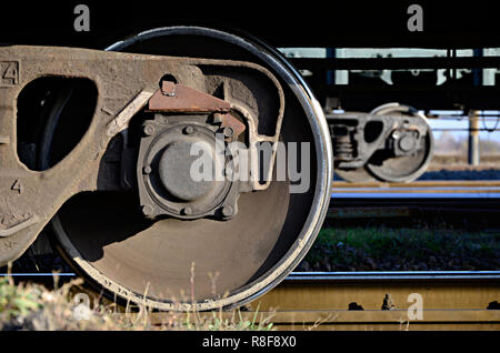 Foto dettagliate del trasporto merci ferroviario auto. Un frammento di parti dei componenti del carro merci su ferrovia in condizioni di luce diurna Foto Stock