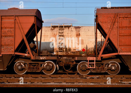 Foto dettagliate del trasporto merci ferroviario auto. Un frammento di parti dei componenti del carro merci su ferrovia in condizioni di luce diurna Foto Stock