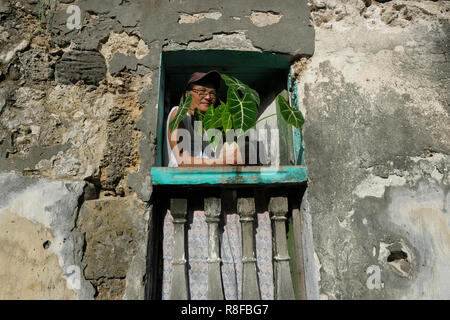 Una donna Ivatan fa capolino da una finestra nel Barrio Savidug situato in Sabtang l isola più meridionale della Batanes isola gruppo il più settentrionale della provincia dell'arcipelago delle Filippine situato nella valle di Cagayan regione Foto Stock