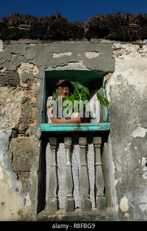 Una donna Ivatan fa capolino da una finestra nel Barrio Savidug situato in Sabtang l isola più meridionale della Batanes isola gruppo il più settentrionale della provincia dell'arcipelago delle Filippine situato nella valle di Cagayan regione Foto Stock