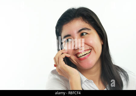 Foto immagine ritratto di un simpatico giovane donna asiatica con mole sembrava molto felice e sorridente quando si parla con il suo amico al telefono su sfondo bianco Foto Stock