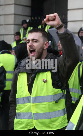 Gli attivisti al di fuori di Custom House prima di marciare a Leinster House a Dublino durante un "Giubbotto giallo' dimostrazione di protesta contro il governo irlandese a registrare su una gamma di questioni sociali. Foto Stock