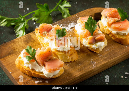 Antipasti sfiziosi spuntini per il vino. Spaghetti con formaggio morbido e il salmone in un rustico di legno su un tavolo di pietra. Foto Stock