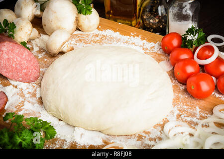 Ingredienti per la classica pizza italiana con la pasta e la verdura con copia spazio nel centro Foto Stock