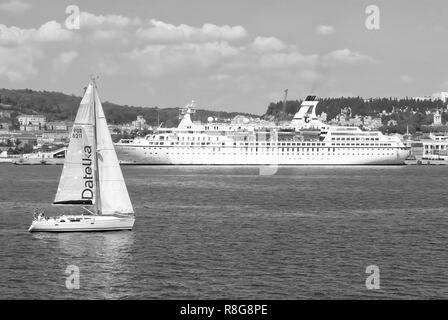 Lisbona, Portogallo - 03 Aprile 2010: barca a vela e la nave sul mare blu costa. Barca a vela e ocean liner in mare. Per viaggi di piacere. Viaggiare in acqua. Vacanze estive e wanderlust. Foto Stock