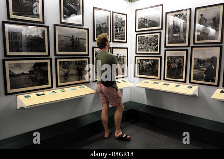 La città di Ho Chi Minh, Vietnam - Un turista studi una mostra fotografica della guerra del Vietnam presso il Museo dei Resti della Guerra di Ho Chi Minh in agosto 2018 Foto Stock