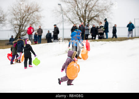 Equitazione per bambini sulla neve slitte in inverno Foto Stock