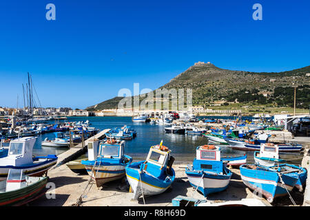 Vista del porto di Favignana pieno di imbarcazioni di pesca artigianale con Forte Santa Caterina in background, Isole Egadi, Sicilia, Italia Foto Stock