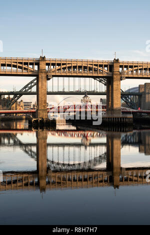 Il livello alto ponte e Tyne Bridge si riflette nel fiume, Newcastle upon Tyne, England, Regno Unito Foto Stock