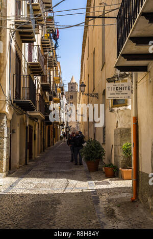 Strada stretta a Cefalù centro storico con il campanile della cattedrale di sfondo. Cefalù, provincia di Palermo, Sicilia, Italia, Maggio 2018 Foto Stock