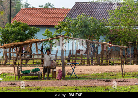 Thakhek, Laos - 20 Aprile 2018: l'uomo facendo un barbecue in un remoto villaggio rurale del sud Laos Foto Stock