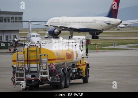 Richmond, British Columbia, Canada. 25 ott 2017. Un guscio del combustibile per aviazione carrello procede lungo la pista di atterraggio all'Aeroporto Internazionale di Vancouver. In background: un Delta Air Lines Boeing 757 parcheggiato su asfalto. Credito: Bayne Stanley/ZUMA filo/Alamy Live News Foto Stock