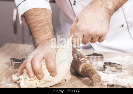 Maschio di cuocere la preparazione di biscotti di Natale, mani close-up Foto Stock