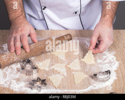 Maschio di cuocere la preparazione di biscotti di Natale, mani close-up Foto Stock