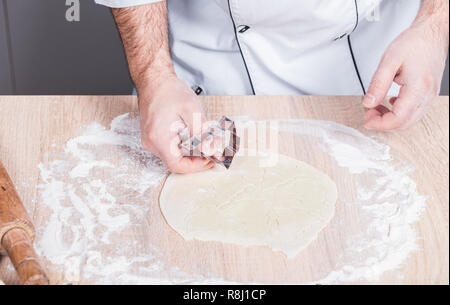 Maschio di cuocere la preparazione di biscotti di Natale, mani close-up Foto Stock