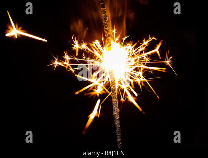 Burning sparkler close-up su sfondo nero Foto Stock
