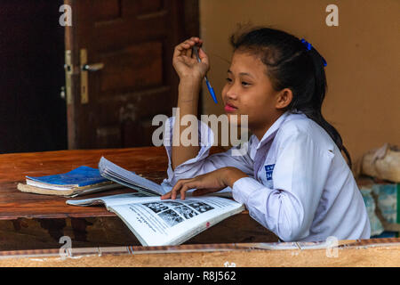 Thakhek, Laos - Aprile 20, 2018: ragazza giovane la lettura di un libro e sognare il futuro Foto Stock