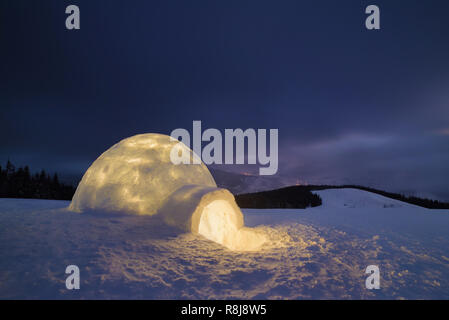 Notte in montagna. Snow igloo con la luce. Alloggiamento estreme. Carpazi, Ucraina, Europa Foto Stock