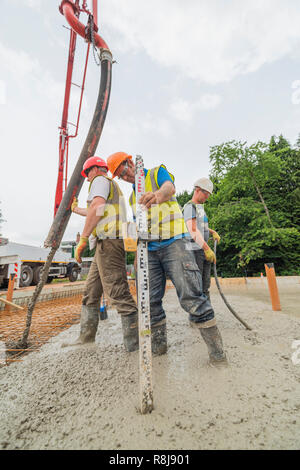 Versando la soletta di calcestruzzo a Maggies Cardiff Foto Stock
