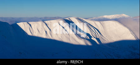 Panorama di montagna con un crinale nevoso. Paesaggio invernale su un soleggiato frosty mattina Foto Stock