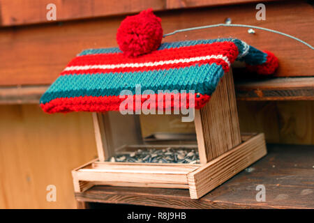 Birdhouse in legno porta una gelatina di lana borsa cap. Decorazione d'inverno. Foto Stock