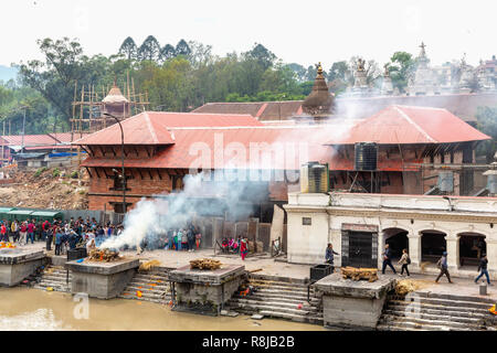 Cremazione indù e funerale sui ghat su fiume Bagmati al sacro Hindu tempio di Pashupatinath a Kathmandu in Nepal Foto Stock