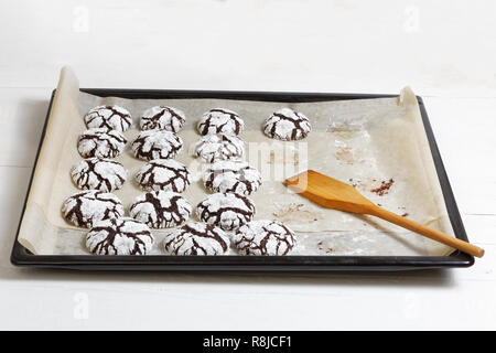 Cioccolato artigianale crinkle cookies su una teglia da forno su bianco tavolo in legno. Foto Stock