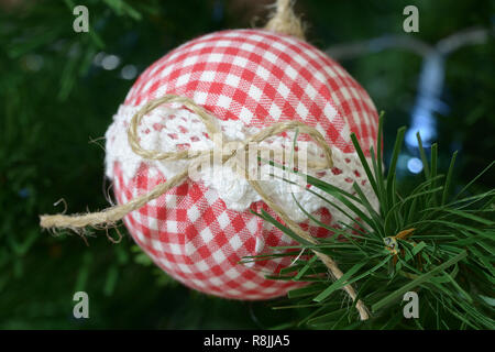 Albero di natale decorazione a sfera. Scopo in casa con il bianco e il rosso tessuto a scacchi Foto Stock
