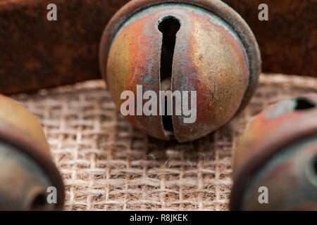 Antique vintage ossidare ottone sleigh bells sul cinturino in pelle e tela sfondo Foto Stock