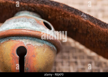 Antique vintage ossidare ottone sleigh bells sul cinturino in pelle e tela sfondo Foto Stock