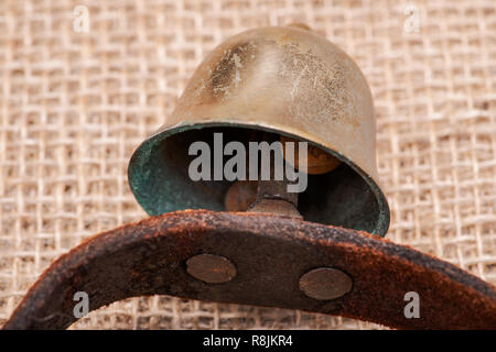 Antique vintage ossidare ottone sleigh bells sul cinturino in pelle e tela sfondo Foto Stock