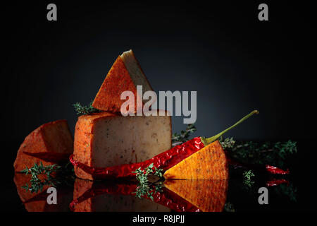 Pecorino rosso pecorino con il timo e il pepe rosso. Tradizionale formaggio di pecora con spises prodotta nel sud dell'Italia. Foto Stock