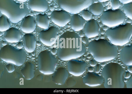 Foto macro. Abstract aqua pattern come sfondo. Immagine di blu. Gocce di acqua sul vetro. Foto Stock